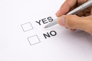 Man hand with pen over document select Yes or No.
